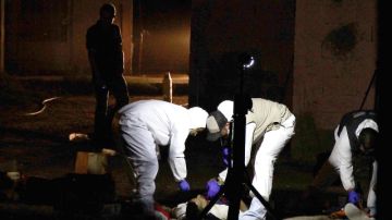 Expertos forenses investigan la escena del crimen  en la población de Loma Blanca en la fronteriza Ciudad Juárez, México.