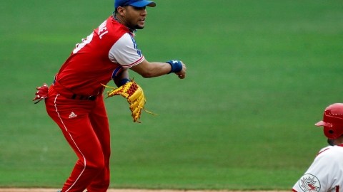 Yulieski Gourriel (izq), antesalista de Cuba, completa una doble matanza en el partido contra  Canadá en 2011.