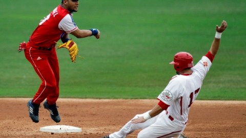 Yulieski Gourriel (izq), antesalista de Cuba, completa una doble matanza en el partido contra Canadá en 2011.