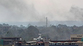 Un hombre hace una llamada telefónica mientras observa una columna de humo que se eleva sobre el centro comercial Westgate en Nairobi (Kenia).