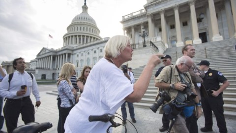 Una ciclista descarga su ira sobre los congresistas republicanos cuando estos pedían en una conferencia de prensa frente al Capitolio, que Harry Reid llame al Senado a votar sobre el presupuesto.