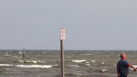 Residentes caminan frente a un mar embravecido en Gulfport, Mississippi.