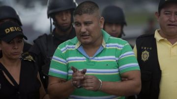 Eduardo Francisco Villatoro Cano, alias "Guayo Cano", es escoltado por agentes de seguridad hoy en Ciudad de Guatemala. Las fuerzas de seguridad de México capturaron en el sureste de ese país al guatemalteco.