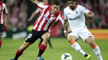 El centrocampista argentino del Valencia, Ever Banega (d), conduce el balón ante el acoso del jugador del Athletic de Bilbao, De Marcos