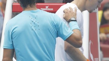 El español Rafael Nadal (izq.) consuela al checo Tomas Berdych, quien tuvo que retirarse de la semifinal del Abierto de  Pekín por problemas en su espalda.
