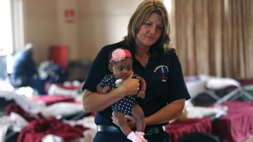 Kristin LeBoeuf sostiene  a  Nevaeh, miembro de una familia obligada a permanecer en un albergue de emergencia en Luisiana.