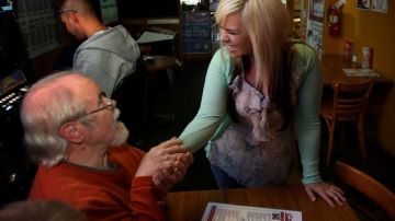 Jerry Arnett (i) felicita a Aurora Kephart, una camarera en Springfield, Oregon, después de enterarse de que ella indirectamente recibió una propina de miles de dólares.