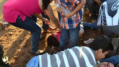 Un hombre trata de levantar a una mujer que resultó herida en el accidente donde hubo varios mueros.