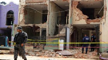 Peritos forenses y policías del estado  de Jalisco investigan en una casa destrozada por los disparos en el municipio de Tepatitlán, Jalisco.