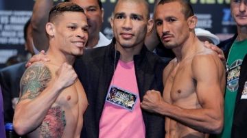 "Fenómeno" Cruz (izquierda) y "Siri" Salido (derecha) posan junto al boxeador Miguel Cotto (centro) luego del pesaje de hoy.