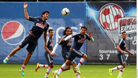 Néstor Vidrio (izq.) cabecea ante la mirada de Miguel Sabah (centro), ayer, en la práctica  de Chivas.