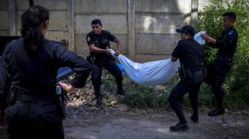 Policías  realizan el levantamiento del cuerpo desmembrado de una mujer  en las afueras de Ciudad de Guatemala.
