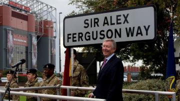 Sir Alex Ferguson, quien fuera técnico del Manchester United durante varios años, sonríe tras develar el letrero que nombra  una calle en su honor.