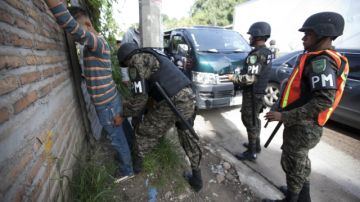 Miembros de la Policía Militar requisan a un hombre, en la colonia La Pradera de Tegucigalpa.