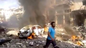 Un hombre camina por los escombros dejados por un  atentado con coche bomba en un mercado de Darkoush en la provincia de Idlib.