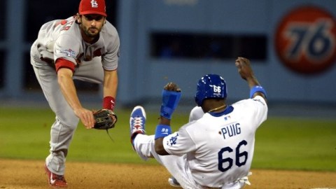 Matt Carpenter (i) de los Cardenales de San Luis completa un doble play ante Yasiel Puig (d) de los Dodgers de Los Ángeles, en el partido jugado en Dodgers Stadium.