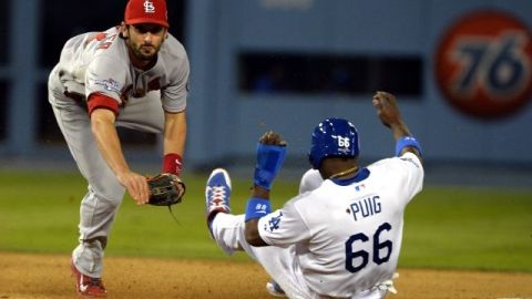 Matt Carpenter (i) de los Cardenales de San Luis completa un doble play ante Yasiel Puig (d) de los Dodgers de Los Ángeles, en el partido jugado en Dodgers Stadium.