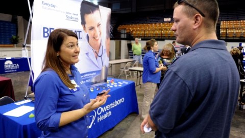 La enfermera Salanda Bowman, izquierda, habla con el universitario del Kentucky Wesleyan College Jason Ward, sobre posibilidades de trabajo en el Hospital Owensboro Health Regional en una feria de trabajo en Owensboro, Kentucky.