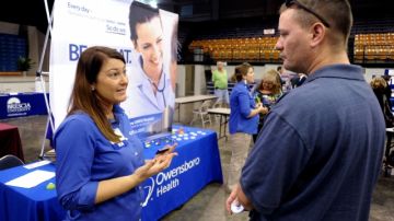 La enfermera Salanda Bowman, izquierda, habla con el universitario del Kentucky Wesleyan College Jason Ward, sobre posibilidades de trabajo en el Hospital Owensboro Health Regional en una feria de trabajo en Owensboro, Kentucky.