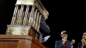 Yadier Molina (izq.) y  Michael Wacha celebran junto al trofeo que acredita a los Cardenales como campeones de la Liga Nacional en 2013.