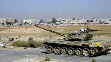 Un tanque de la Armada siria patrulla las calles de un barrio al norte de Damasco.