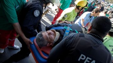 La policía y personal médico transportan a uno de los heridos por el choque del tren ayer en Buenos Aires.