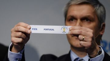 El jefe del Departamento de Competición y Encuentros Eliminatorios de la FIFA, Gordon Savic, muestra el nombre de Portugal en el sorteo para el repechaje.