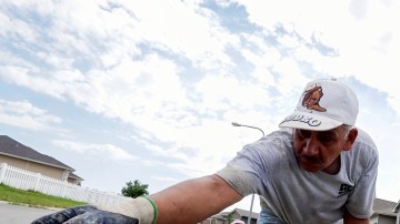 Un trabajador le da forma a una acera frente a un grupo de nuevas casas construidas en Omaha, Nebraska. Según un estudio del BPC, la reforma migratoria impulsaría el sector de la construcción.