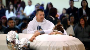 Sujey López,  junto a su esposo Rodrigo, abraza el ataúd con los restos de su hijo  Andy, durante la misa de cuerpo presente realizada en la Parroquia de la Resurrección en Santa Rosa, California.