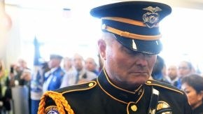 El oficial de policía de LAX Tom Dye pasa a la Bandera de Honor de EEUU a la  guardia de honor Brandy Richards, de TSA, en el Aeropuerto Internacional de Los Ángeles, en un acto en memoria de del agente de TSA Gerardo Hernández.