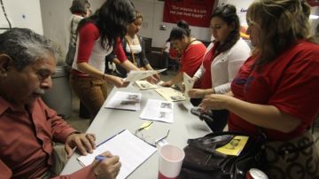 Varias personas se inscriben durante su participación en una reunión comunitaria de la Unión del Pueblo Entero (LUPE) en San Juan, al sur de Texas.