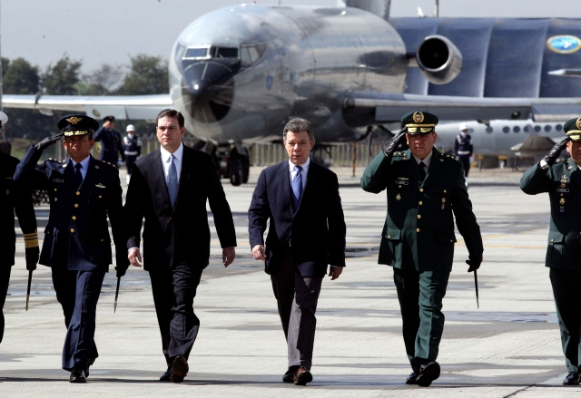 El presidente de Colombia Juan Manuel Santos (c) marcha junto al ministro de defensa, Juan Carlos Pinzón (2-d), durante la celebración del 94 aniversario de la Fuerza Aérea Colombiana  en el Comando Aéreo de Transporte Militar en Bogotá