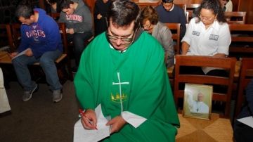 El padre Brian Jordan del colegio San Francisco de Asís y un grupo de estudiantes redactan algunas de las peticiones al papa Francisco.