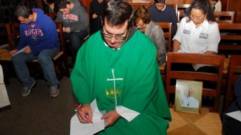 El padre Brian Jordan del colegio San Francisco de Asís y un grupo de estudiantes redactan algunas de las peticiones al papa Francisco.