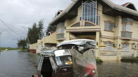 Un hombre circula con su moto por las calles inundadas de Taguig al paso del tifón 'Haiyan' en Taguig,Filipinas.