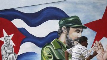 Un hombre cruza frente a un mural con las imágenes del líder cubano Fidel Castro y del presidente nicaragüense, Daniel Ortega, en la Plaza Cuba, en Managua, Nicaragua.
