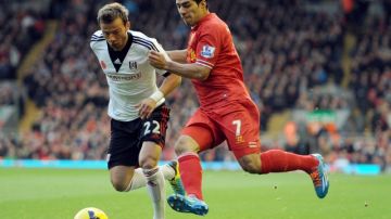Luis Suárez (der.) batalla con Elsad Zverotic  en un trámite del partido  entre Liverpool y Fulham disputado ayer en Anfield Road.
