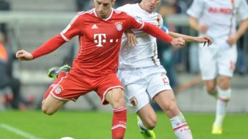 Franck Ribery y Paul Verhaegh del  Augsburgo disputan el balon durante el juego de ayer en  Munich.