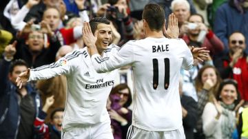Cristiano Ronaldo (i), delantero del Real Madrid, celebra con su compañero galés Gareth Bale, uno de los tres goles que  marcó a la Real Sociedad, en partido disputado ayer en el estadio Santiago Bernabéu.