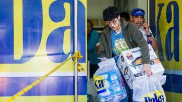 Un hombre sale con algunas compras de electrodomésticos en una de las sedes de la cadena dse tiendas Daka  en Caracas.