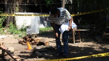 Un investigador recoge evidencias en el lugar donde fueron encontrados los cadáveres  en el estado de Guerrero.