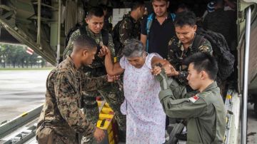 Militares trasladan a una envejeciente a la base aérea Villamor, en Filipinas.
