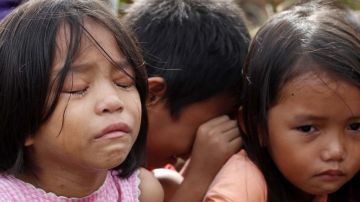 Un grupo de niños llora tras escapar de su pueblo después de que éste fuera atacado por hombres armados en Filipinas.