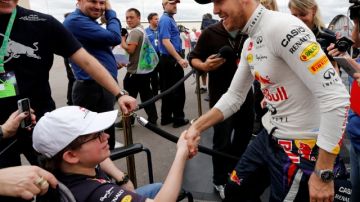 Sebastian Vettel (d) saluda a un aficionado tras las pruebas calificatorias.