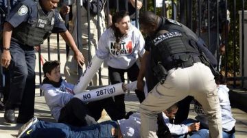 Varios policías arrestan a un grupo de manifestantes en el exterior de la oficina de ICE, en Atlanta.