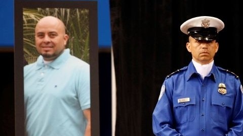 Un oficial de TSA junto al retrato de Gerardo Hernández, durante un homenaje en Los Ángeles Sports Arena, el 12 de noviembre de 2013.