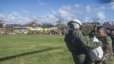 Un soldado del ejército de EEUU entrega provisiones a u soldado filipino en Giporlos, Filipinas, para ayudar a las víctimas del tifón.