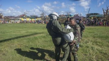 Un soldado del ejército de EEUU entrega provisiones a u soldado filipino en Giporlos, Filipinas, para ayudar a las víctimas del tifón.