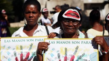 Mujeres sostienen carteles durante una manifestación con motivo del Día Internacional de la Eliminación de la Violencia.