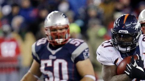 El corredor Knowshoon Moreno protege el balón del asedio de los Patriots durante el pasado juego nocturno del domingo.